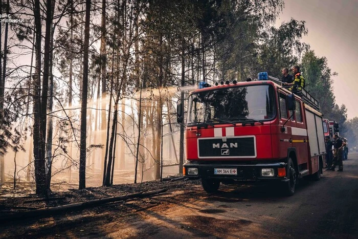 Firefighters extinguishing fire in open area