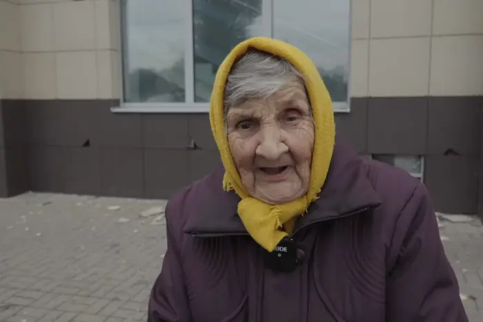 Elderly woman delicately holds a phone in her hands