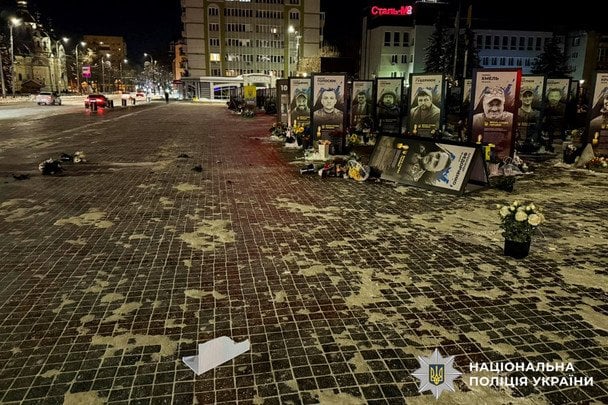 Жінка перекидає портрети воїнів